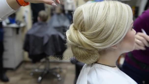Egy visagiste teszi a frizurát és egyéb festékek ajkak lány modell. — Stock videók