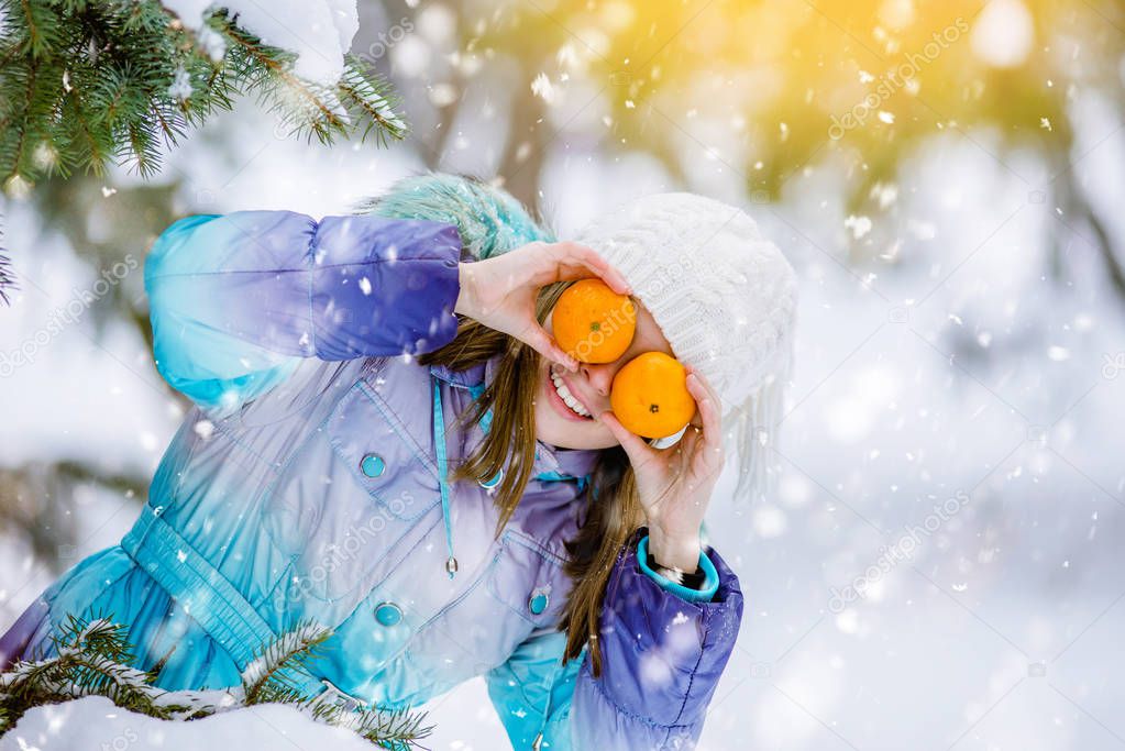 Girl and tangerines. cheerful teen girl holding oranges near the face. Healthy girl with vitamins in form of citrus fruits. healthy diet for teenagers, vitamin deficiency in winter