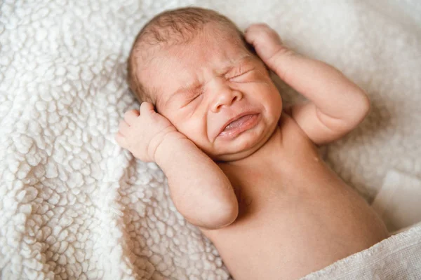 Novorozený chlapeček brečet v postýlce. Novorozence baby boy v posteli. — Stock fotografie