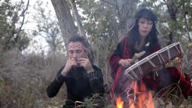 şamanik kadın şaman çerçeve davul yangın ve harp oynayan bir adam etrafında doğada oynamaya