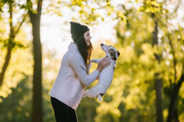 güzel kız bir köpekle oynamayı. Köpekle park üzerinde oynamak. Yakın çekim portre. Jack Russell Terrier