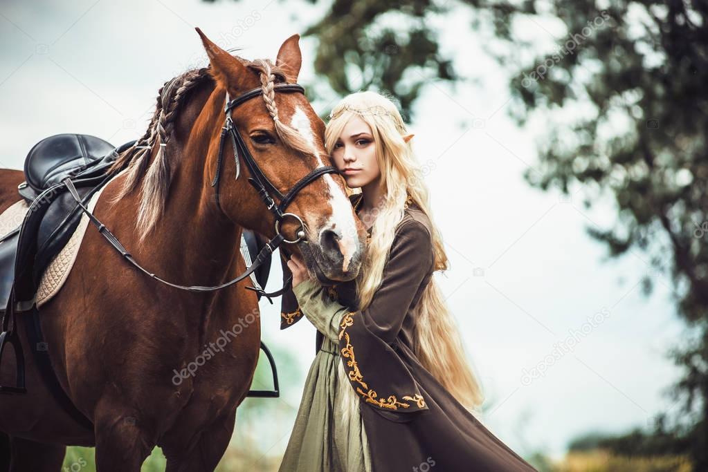 Elf woman in the forest with a horse