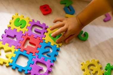 Renkli köpük bulmaca harf ve rakam çocuklara olan eller üzerinde masa lambası