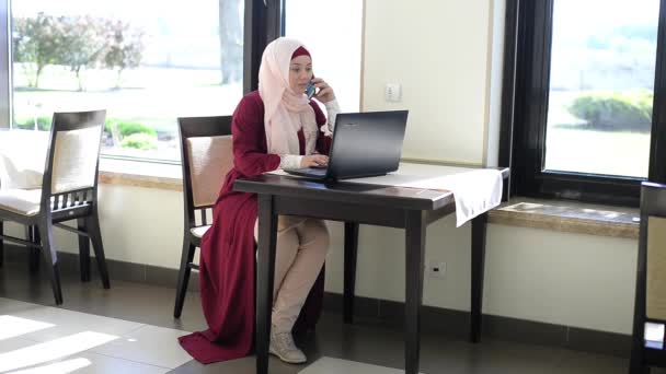 Vacker muslimsk kvinna i café med tablett — Stockvideo