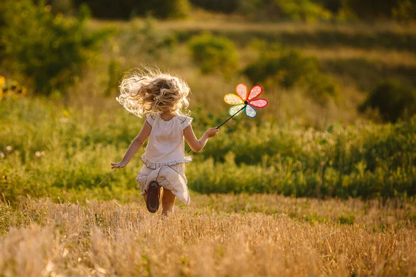 Bonita menina brincando no campo de verão de trigo — Fotografia de Stock