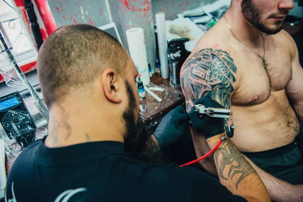 El proceso de crear un tatuaje en la espalda de un hombre —  Fotos de Stock