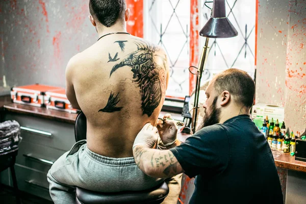 Proces tworzenia tatuaż na plecach człowieka — Zdjęcie stockowe