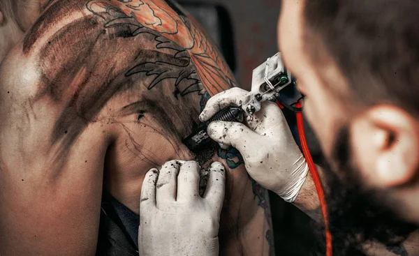 The process of creating a tattoo on the back of a girl — Stock Photo, Image