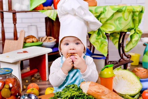 Dziewczynka w ubrania kucharz z Bajgle w rękach — Zdjęcie stockowe