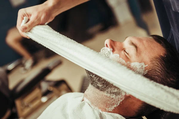 Hombre afeitándose la barba en el peluquero profesional —  Fotos de Stock