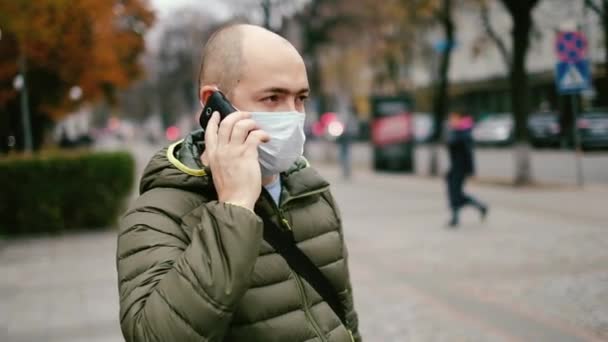 Een man in een masker op straat. Bescherming tegen virussen en besmetting — Stockvideo