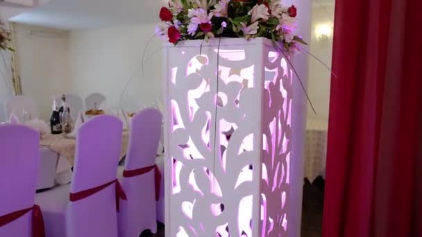 Esküvői díszített terem növényzettel. Asztalbeállítás friss virágokkal. Bankett terem — Stock videók