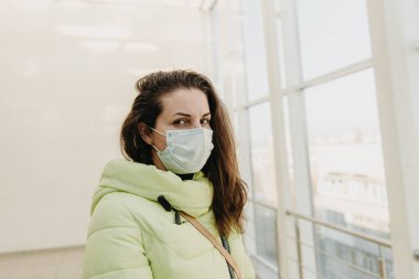 Virüse karşı koruyucu bir maske takan bir adam binanın içinde duruyor. Karantina, salgın hastalık...