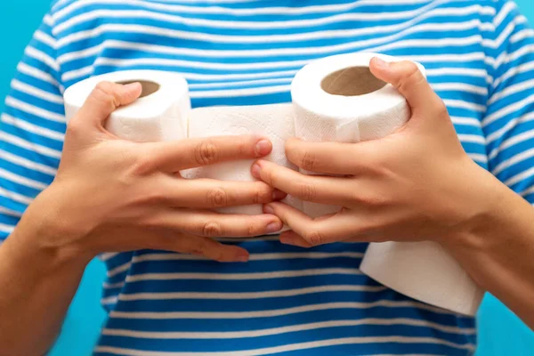 man holds an armful of rolls of toilet paper. the hype around the demand for toilet paper during the global pandemic of the coronavirus. studio isolated.