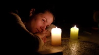Elinde mum olan sakin bir kadın. Kız yanan mumu izliyor..