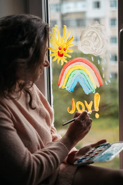 Женщина пишет слово радость на окне — стоковое фото