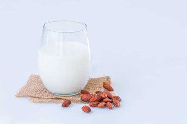Mandlové mléko ve skle s mandlového semínka na mramorový stůl. — Stock fotografie