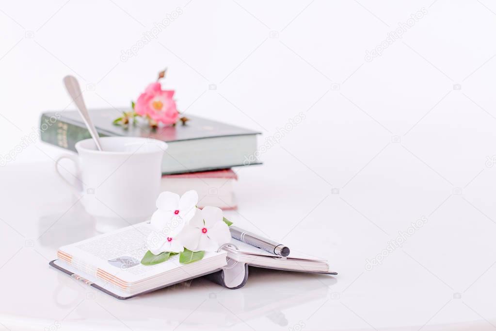 Open book with flowers and coffee in the morning.