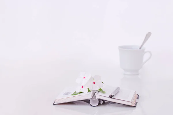 Öppen bok med blommor och kaffe på morgonen. — Stockfoto