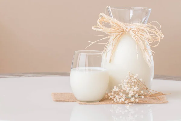 Ett glas mjölk och en kanna mjölk på marmor bord. — Stockfoto