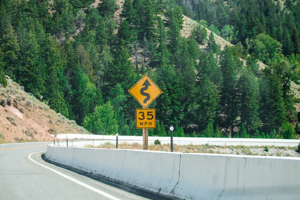 Limite de velocidade sinal de trânsito, 35 MPH e estrada sinuosa . — Fotografia de Stock