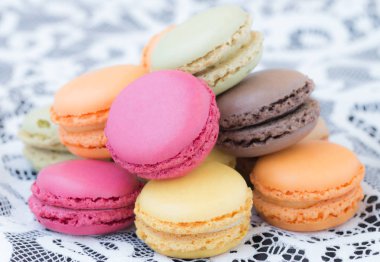 Beyaz dantel arka plan üzerinde renkli macaroons.