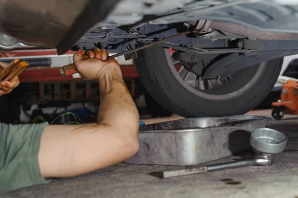 Μηχανικός αυτοκινήτων χαλαρώσει φίλτρο λαδιού — Φωτογραφία Αρχείου
