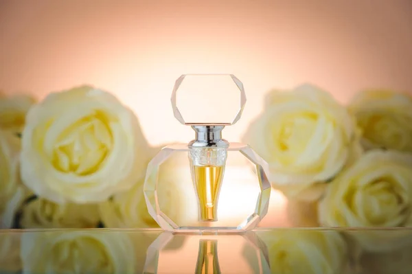 Хрустальная бутылка на фоне белых роз — стоковое фото