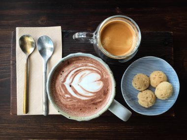 Bir fincan sıcak çikolatanın üst görüntüsü latte sanatıyla, espresso kahvesiyle