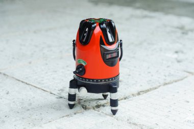 İnşaat alanında lazer seviyesi makinesi var. Seviye ölçümü için kırmızı lazer ışığı çizgileri