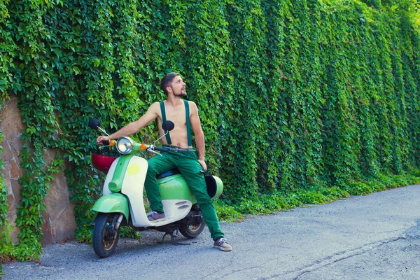 Um cara no verão em uma scooter olha para o céu — Fotografia de Stock