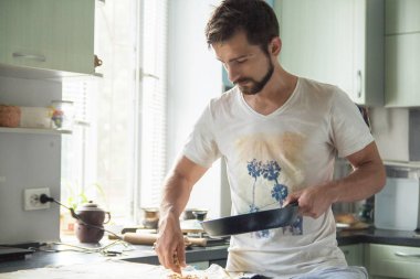 Mutfakta adamla onun elinde bir kızartma tavası