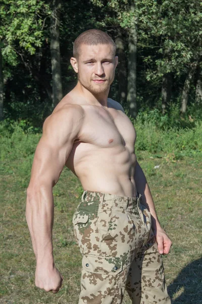 Grote man met spieren in camouflage broek — Stockfoto