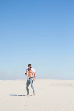 Beyaz kumları arasında açılarak bir Beyaz gömlekli parlak adam