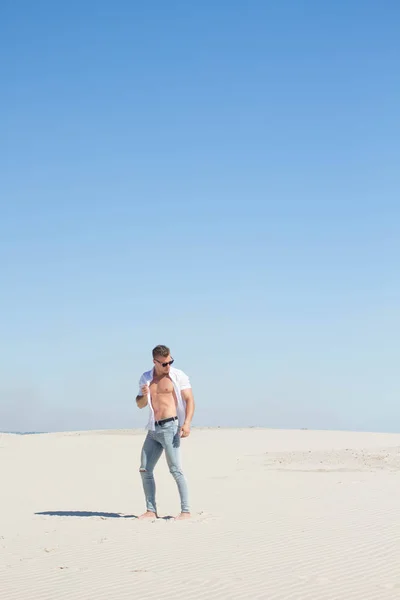 Tipo brillante en una camisa blanca desabotonada entre las arenas blancas —  Fotos de Stock