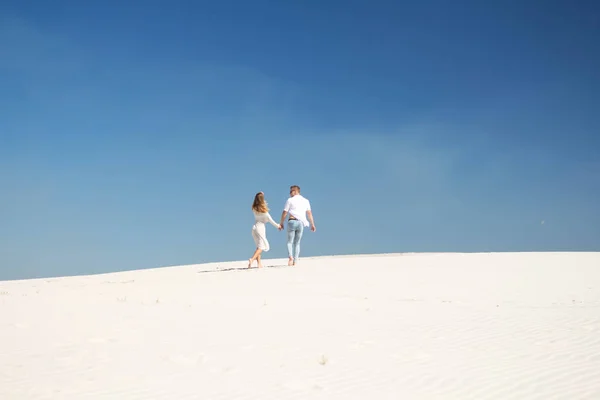 Красива пара на відстані між білими безмежними пісками — стокове фото
