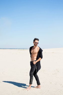 Şık, atletik bir adam kum zemin üzerine
