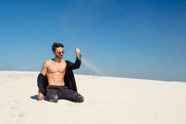 Genç bir adam güzel bir el ile kum dökülen