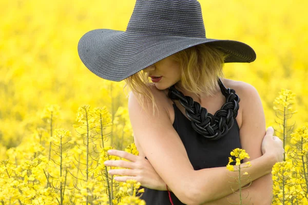 Kız kendini kucaklayan ve hafifçe dokunur çiçek — Stok fotoğraf