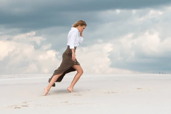 En tunn tjej går tungt övervinna den starka vinden — Stockfoto