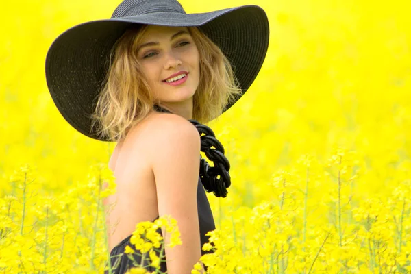 Sahada sarı çiçekler sevimli gülümseyen kız — Stok fotoğraf