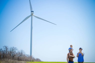 Gey bir çocuğun yanında bir rüzgar jeneratörü ile bir çift