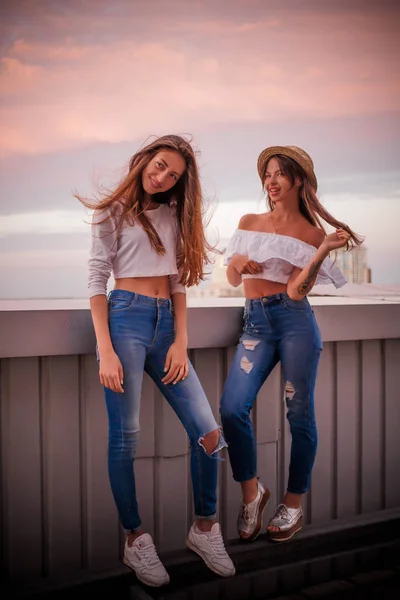 Due sorelle in top bianchi e jeans strappati — Foto Stock