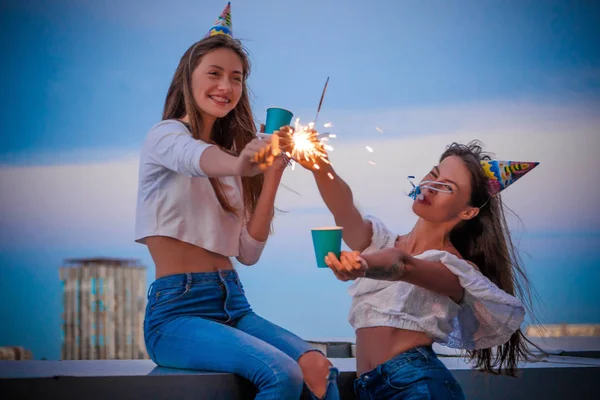 Duas meninas com luzes de Bengala e óculos de papel celebram seu aniversário — Fotografia de Stock