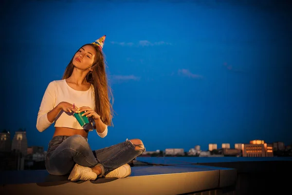 A menina pensativo enquanto sentado com uma xícara sob o céu noturno — Fotografia de Stock