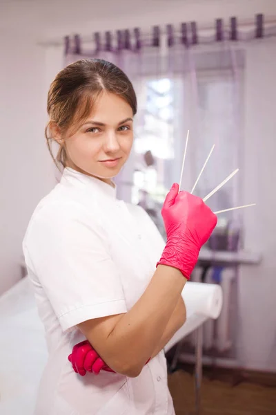 Косметолог в белой мантии и розовых перчатках — стоковое фото