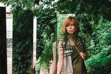 Aynalar ve yaprak yeşil ile sokaktaki kız