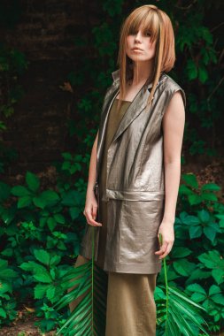 Kız bir duvar sarmaşık olan bir arka plan üzerinde