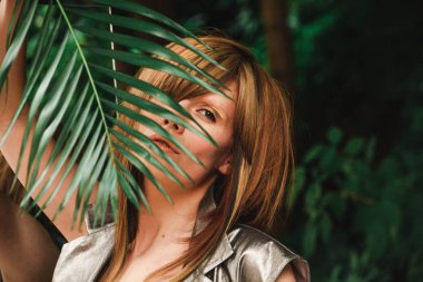 Bir kız bir fern şube görünüyor