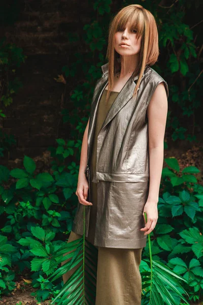 Kız bir duvar sarmaşık olan bir arka plan üzerinde